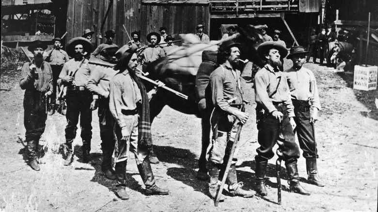 old west prospectors carrying their gear