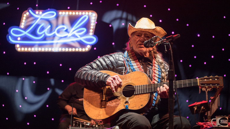 Willie Nelson singing neon sign saying Luck