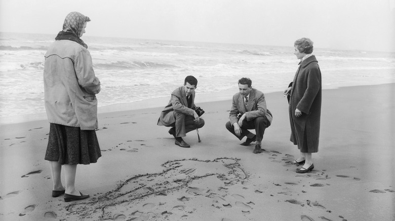 four people on beach examine crime scene wilma montesi