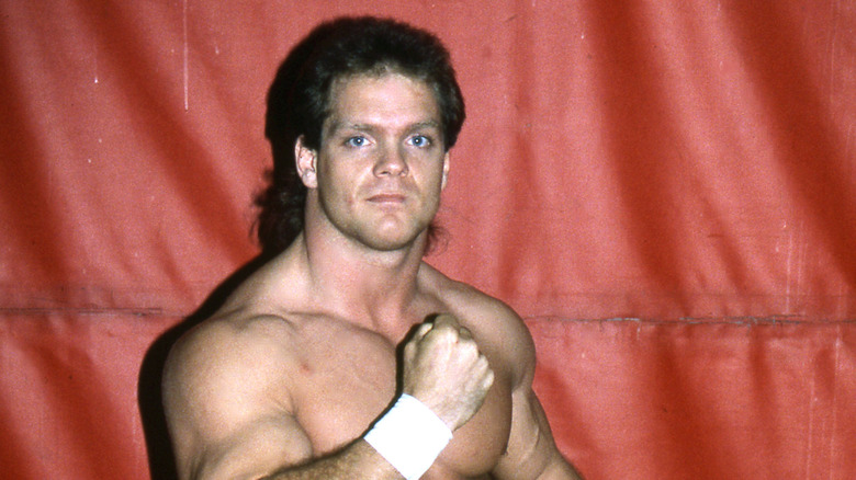 Chris Benoit posing shirtless against red background