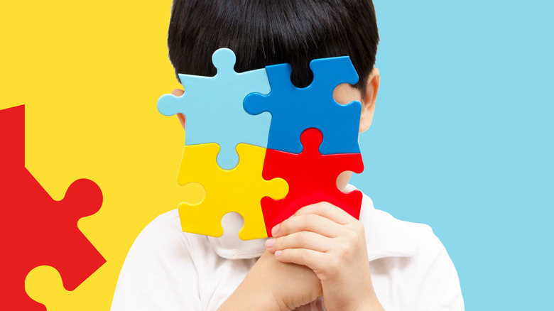 boy's face hidden behind puzzle pieces