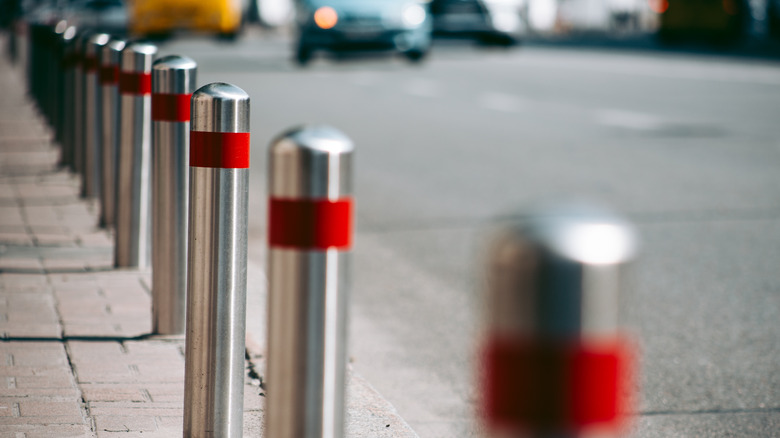 Metal safety bollards line city street 